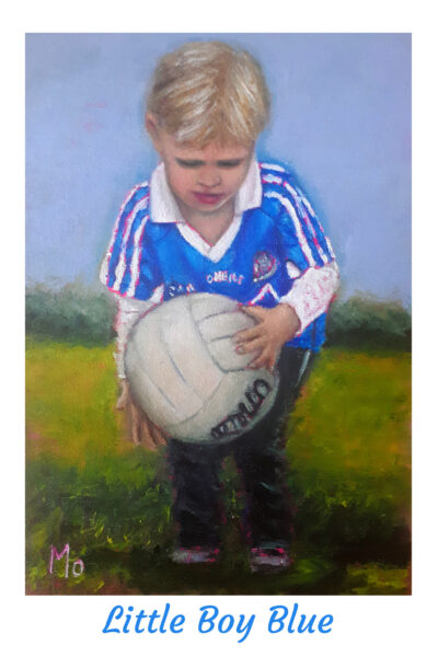 Boy in Dublin GAA jersey holding a football