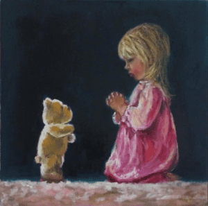 Little girl praying with her teddy bear